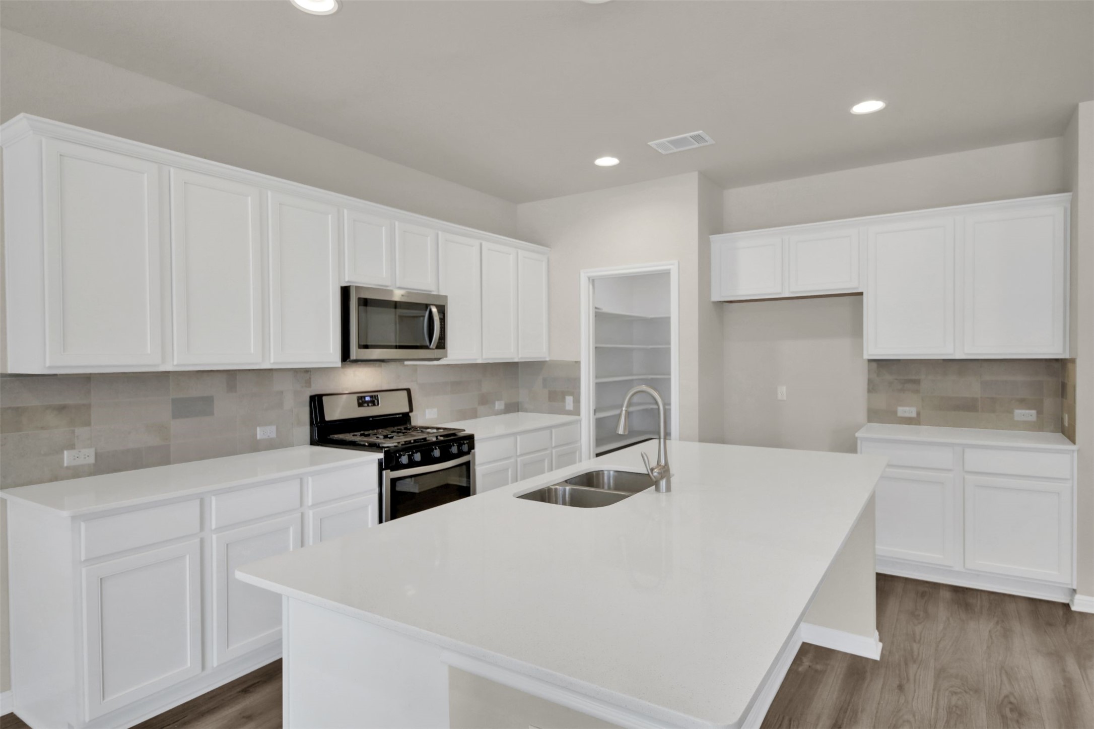 1829 Chickasaw Run Leander, TX 78641 - Photo 13 of 40 a kitchen with granite countertop a sink stove and microwave