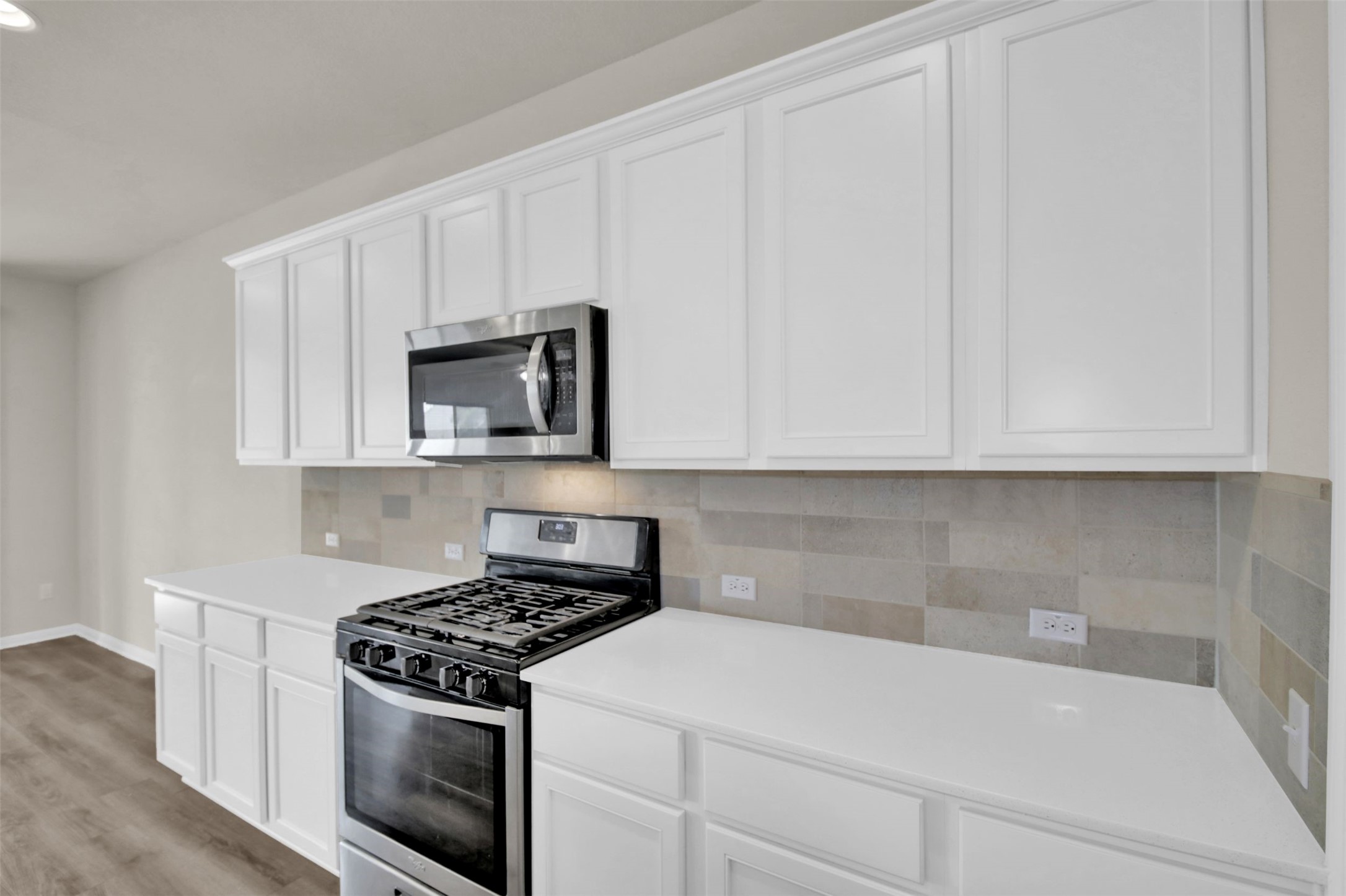 1829 Chickasaw Run Leander, TX 78641 - Photo 10 of 40 a kitchen with white cabinets and stainless steel appliances