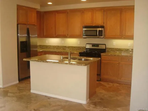 a kitchen with sink a microwave a refrigerator and cabinets