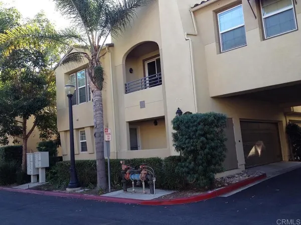 a front view of a house with yard and parking