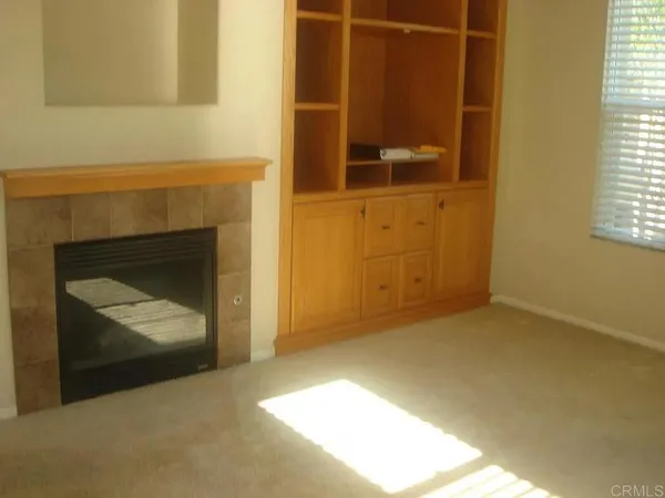 a view of an empty room with a fireplace and a window