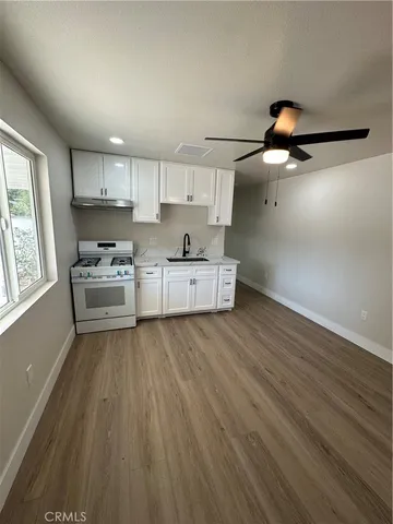 a kitchen with stainless steel appliances wooden floors and view living room