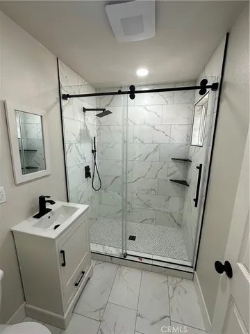 a bathroom with a sink mirror vanity and shower