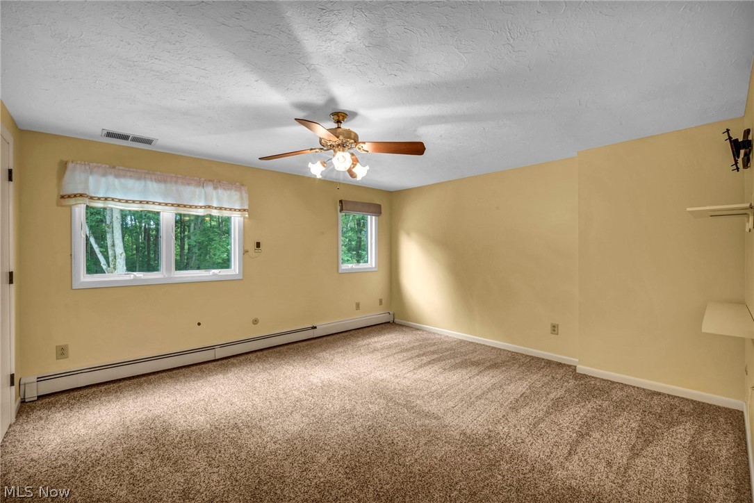 6845 Liberty Road Solon, OH 44139 - Photo 22 of 47 Carpeted room featuring multiple windows, a ceiling fan with integrated lighting, and built-in shelving