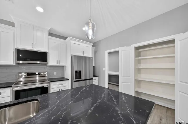 a kitchen with a refrigerator and a stove top oven