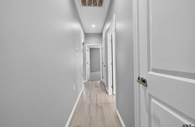 a view of a hallway with wooden floor