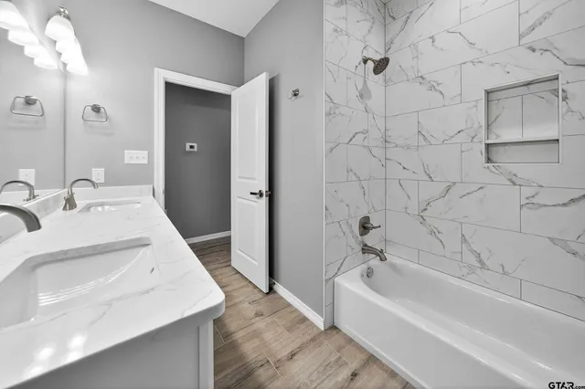 a bathroom with a tub sink and mirror