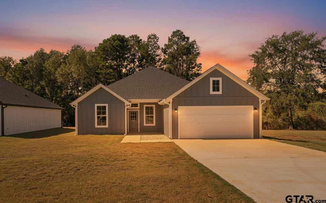 a front view of a house with a yard and trees