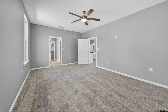 an empty room with closet and ceiling fan
