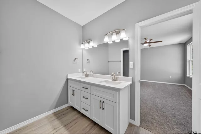 a bathroom with a double vanity sink and a mirror