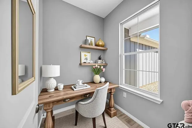 a view of a workspace with furniture and a window