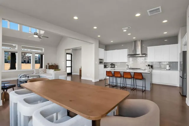 a living room with stainless steel appliances furniture and a kitchen view