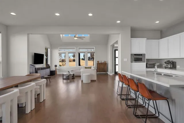 a large white kitchen with lots of counter space and stainless steel appliances