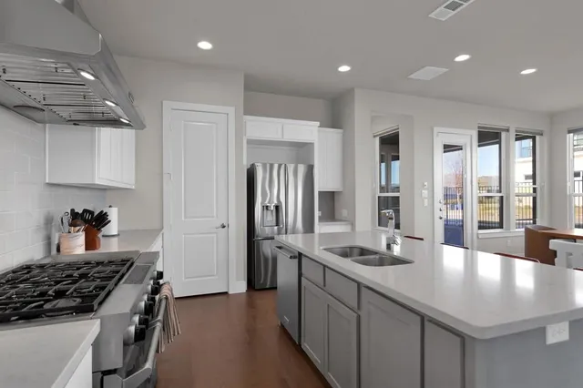 a kitchen with stainless steel appliances granite countertop a sink stove and refrigerator