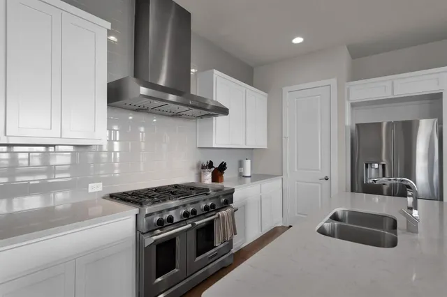 a kitchen with stainless steel appliances granite countertop a sink stove and cabinets