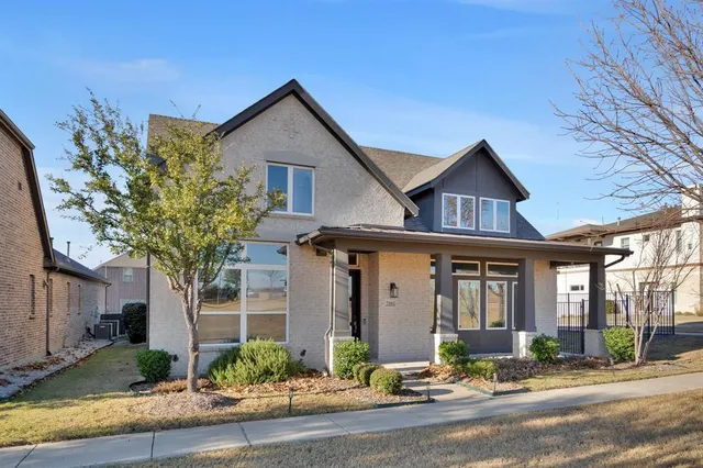 a front view of a house with yard tree and outdoor seating