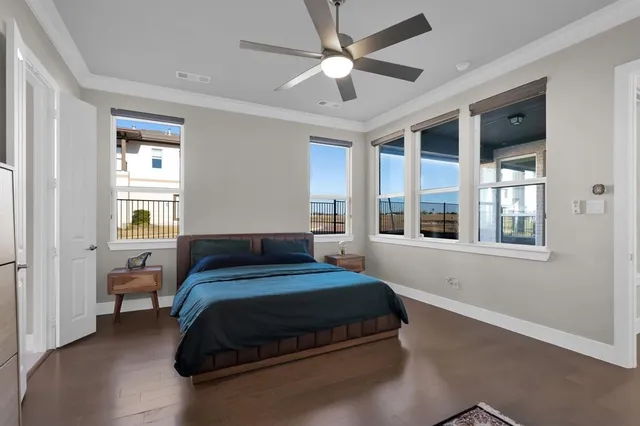 a bedroom with a large bed chandelier and a window
