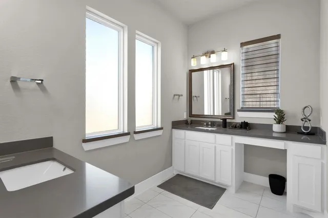 a bathroom with double vanity and a bathtub