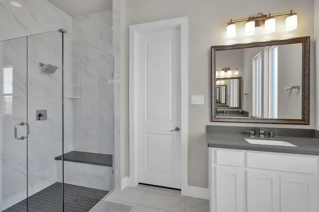 a bathroom with a double vanity sink mirror and shower
