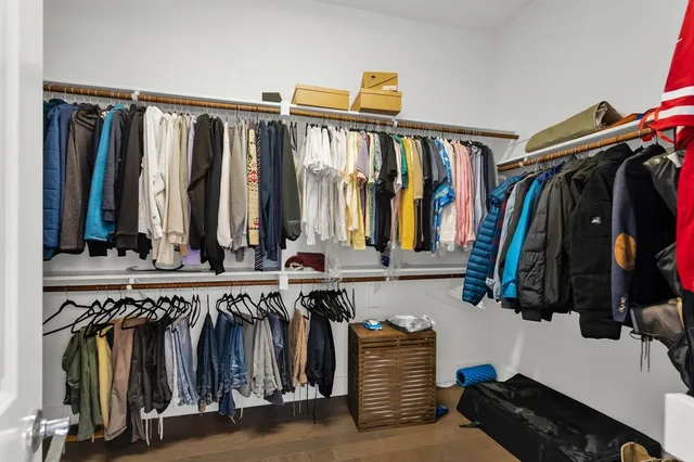 a view of walk in closet with clothes and shoes