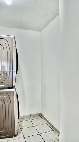 a view of a hallway with white cabinets