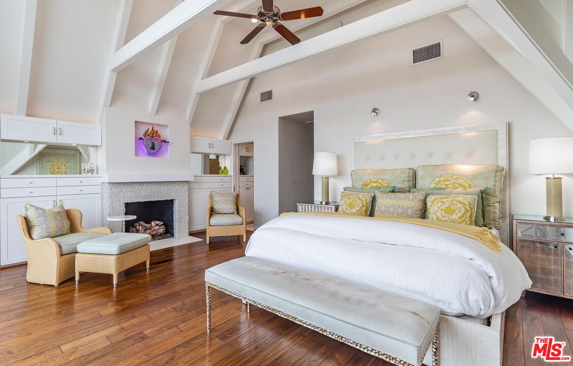 23416 Malibu Colony Road Malibu, CA 90265 - Photo 14 of 26 a spacious bedroom with a bed a couch and a fireplace