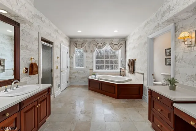 a bathroom with a tub sink and mirror