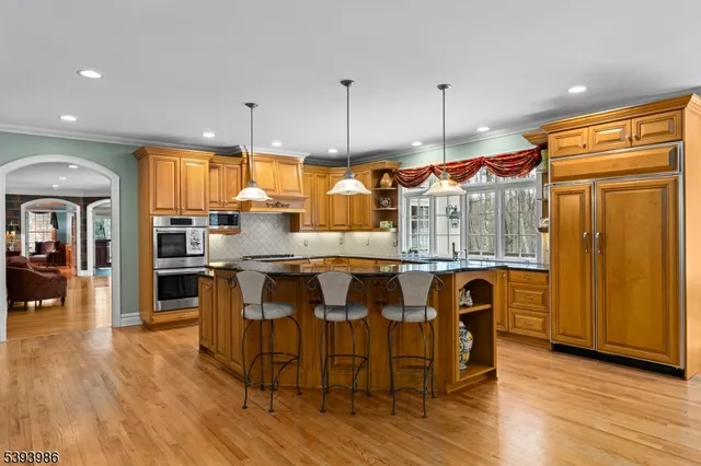 a kitchen with granite countertop a table chairs stove refrigerator and cabinets