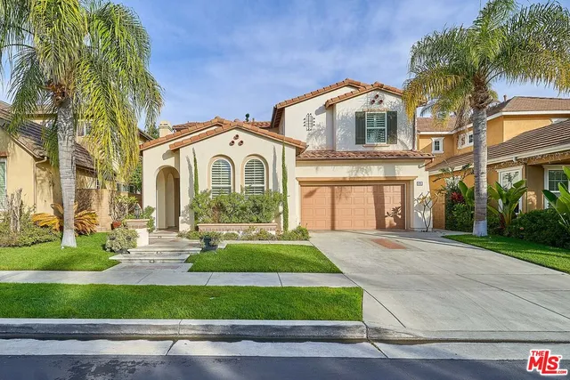 a front view of a house with a garden and plants