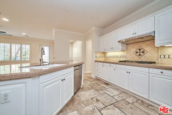 a kitchen with granite countertop white cabinets and white appliances