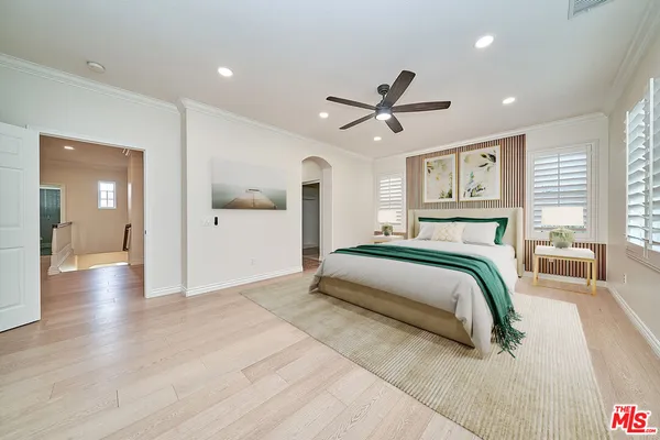 a bedroom with a large bed and a chandelier