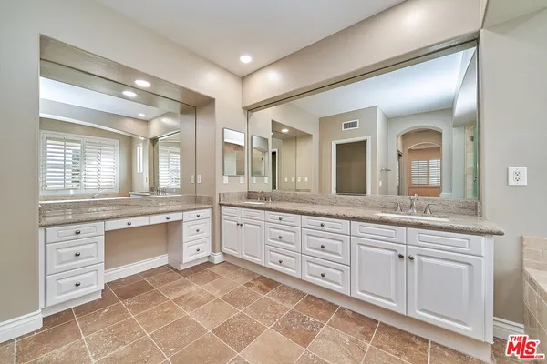 a spacious bathroom with a granite countertop sink mirror and
