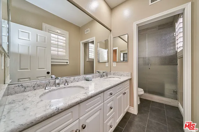 a bathroom with a granite countertop sink mirror and double