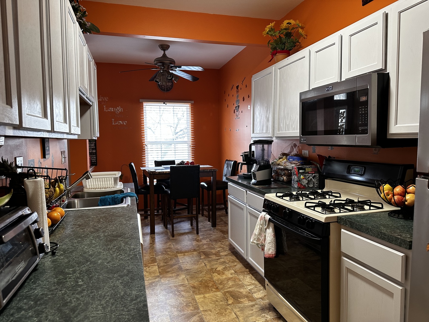 2255 Reflections Drive Aurora, IL 60502 - Photo 6 of 20 a kitchen with stainless steel appliances granite countertop a stove top oven a sink a dining table and chairs with wooden floor