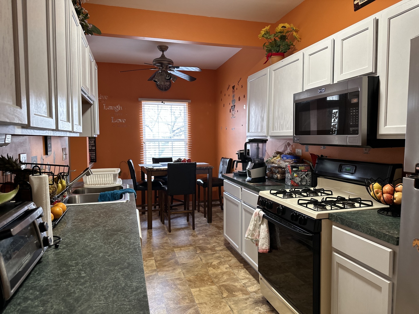 2255 Reflections Drive Aurora, IL 60502 - Photo 7 of 20 a kitchen with stainless steel appliances granite countertop a stove top oven a sink a dining table and chairs with the cabinets