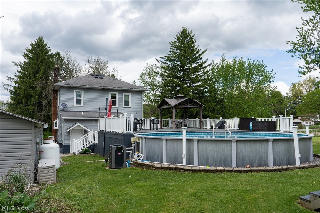 13429 West Calla Road Salem, OH 44460 - Photo 22 of 27 Expansive backyard featuring an above-ground pool, a connected deck with white railings, and a gazebo