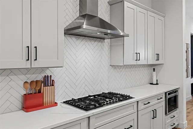 a kitchen with stainless steel appliances granite countertop a stove and white cabinets