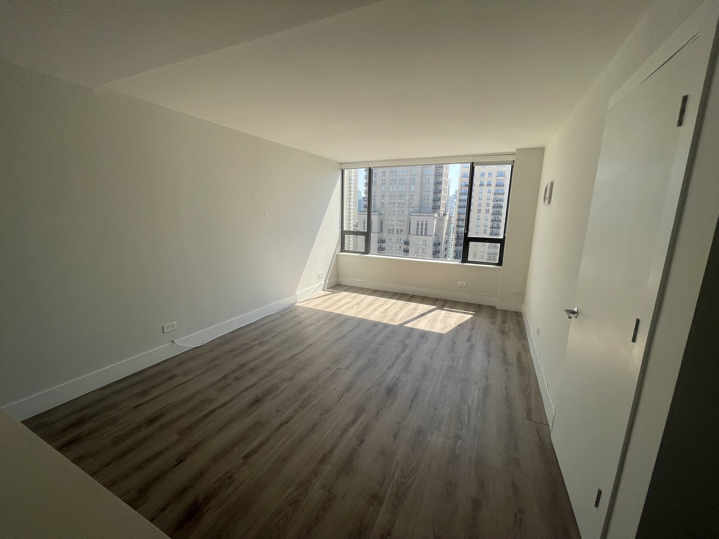 Undisclosed Address Chicago, IL 60611 - Photo 5 of 13 an empty room with wooden floor and windows