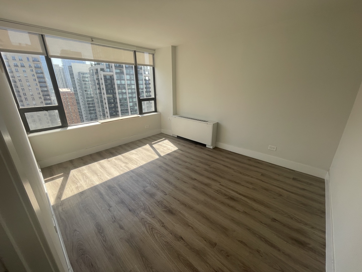 Undisclosed Address Chicago, IL 60611 - Photo 8 of 13 a view of an empty room with wooden floor and a window