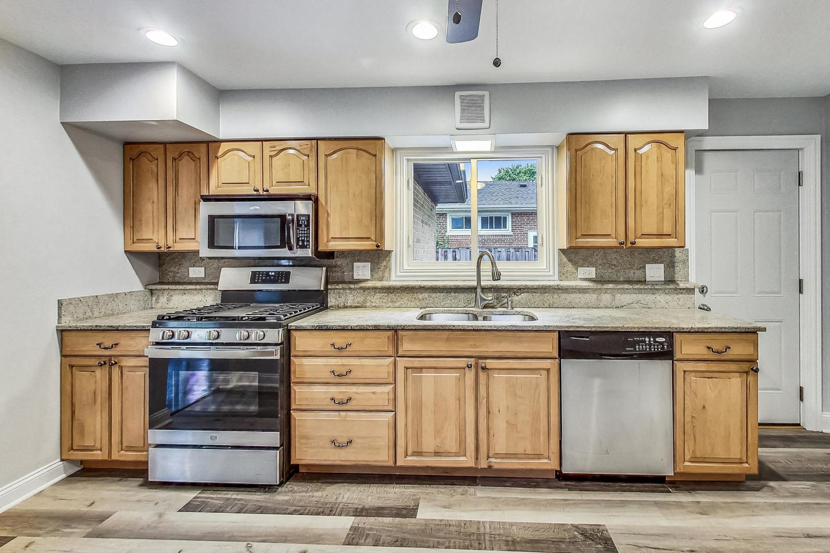 111 South We Go Trail Mount Prospect, IL 60056 - Photo 10 of 46 a kitchen with stainless steel appliances granite countertop a stove a sink and a microwave