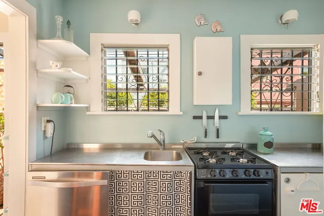 a kitchen with kitchen island a stove a sink and a window