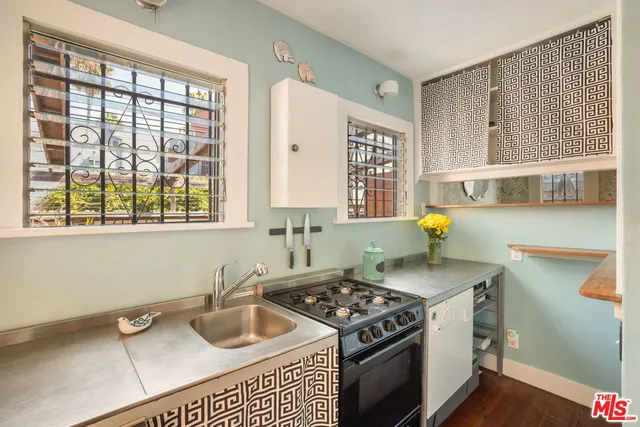 a kitchen with a stove a sink and a window