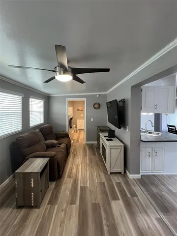 a living room with furniture a flat screen tv and kitchen view
