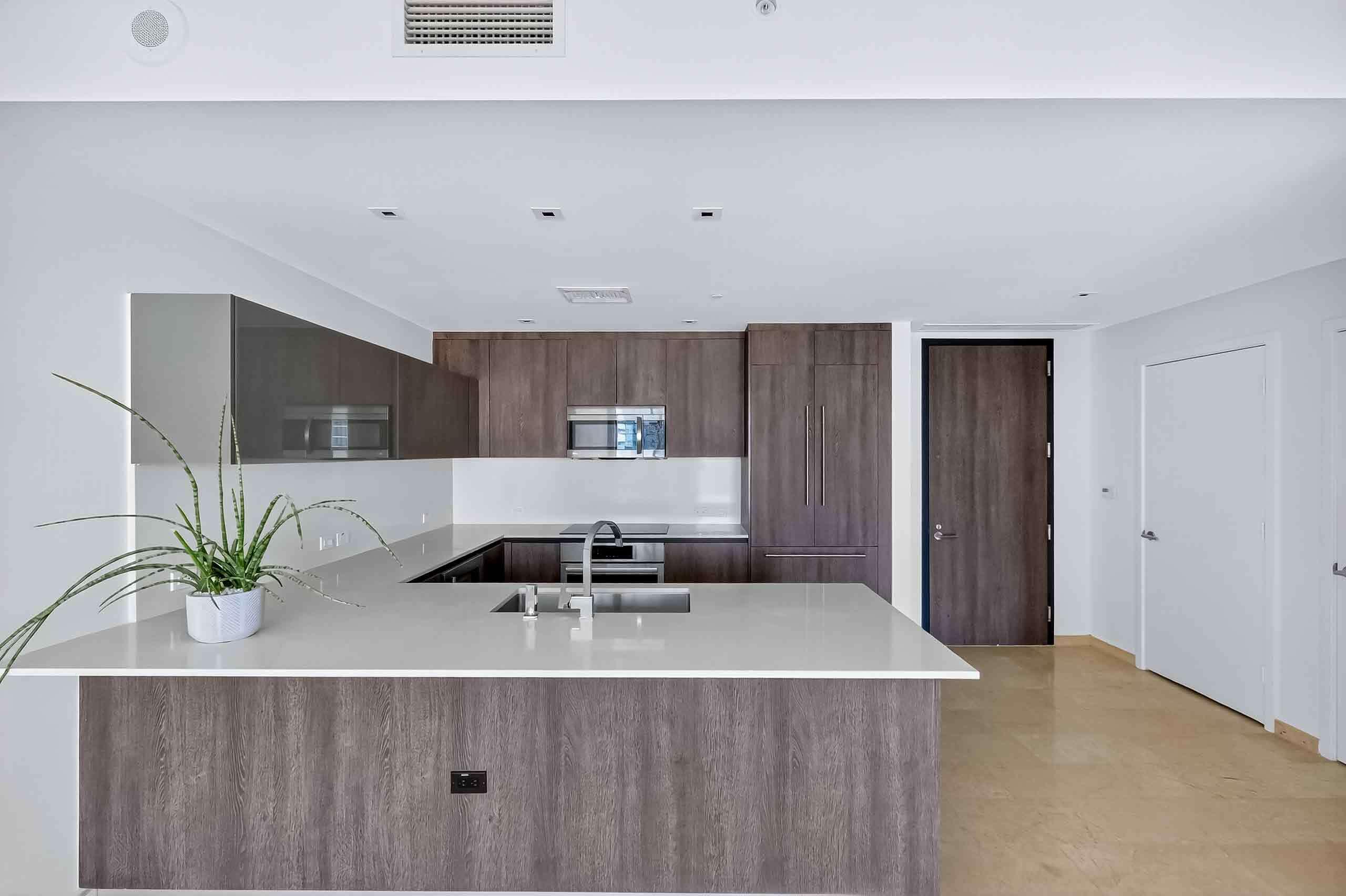 88 Southwest 7th Street, Unit 3003 Miami, FL 33130 - Photo 3 of 49 a view of a kitchen with kitchen island a counter top space and a sink
