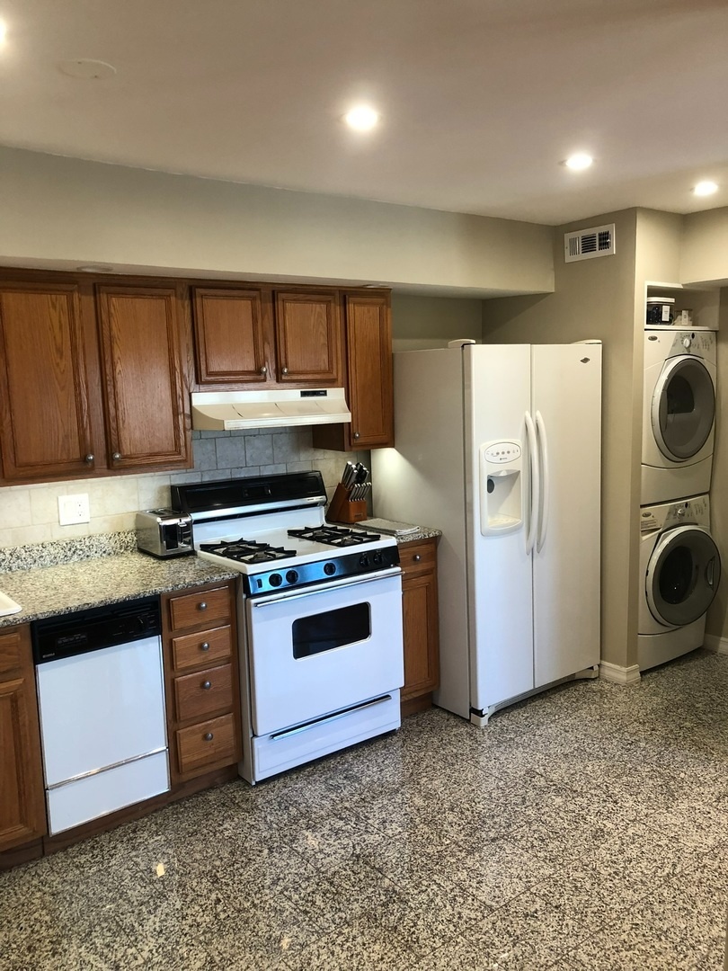941 North Northwest Highway, Unit 3B Park Ridge, IL 60068 - Photo 11 of 26 a kitchen with stainless steel appliances granite countertop a stove a refrigerator and a sink with wooden cabinets
