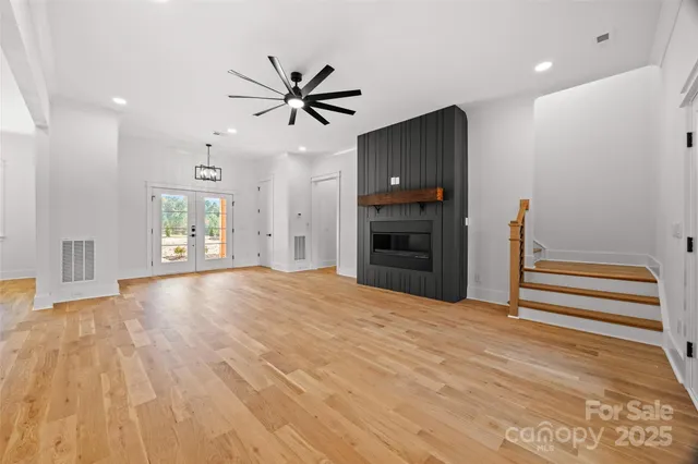 a view of empty room with wooden floor and window