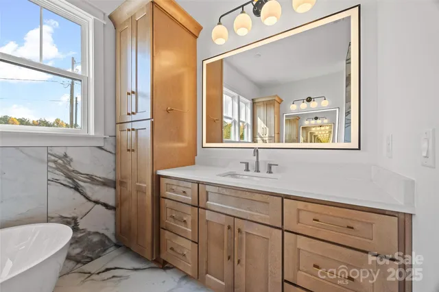 a bathroom with a granite countertop toilet sink and mirror