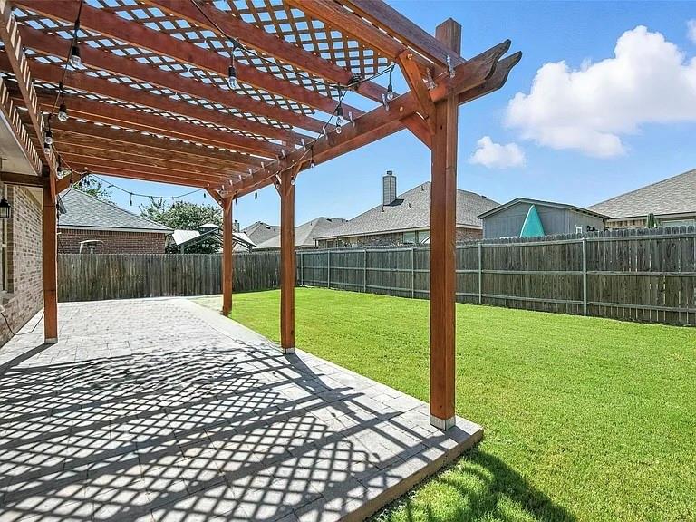5817 Deck House Road Fort Worth, TX 76179 - Photo 16 of 19 Expansive backyard featuring a paver patio with a wooden pergola, string lighting, and a substantial lawn area