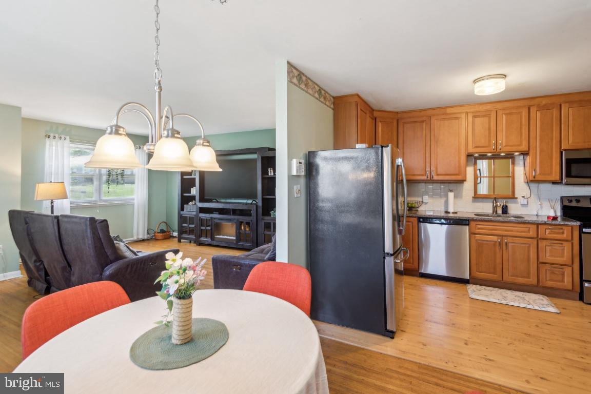 144 Elmtowne Boulevard Hammonton, NJ 08037 - Photo 8 of 25 a kitchen with stainless steel appliances granite countertop a refrigerator a stove a sink dishwasher a dining table and chairs with wooden floor