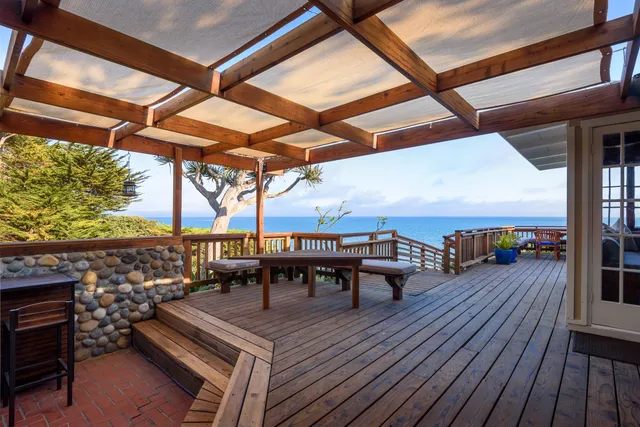 a view of a balcony with chairs and wooden floor